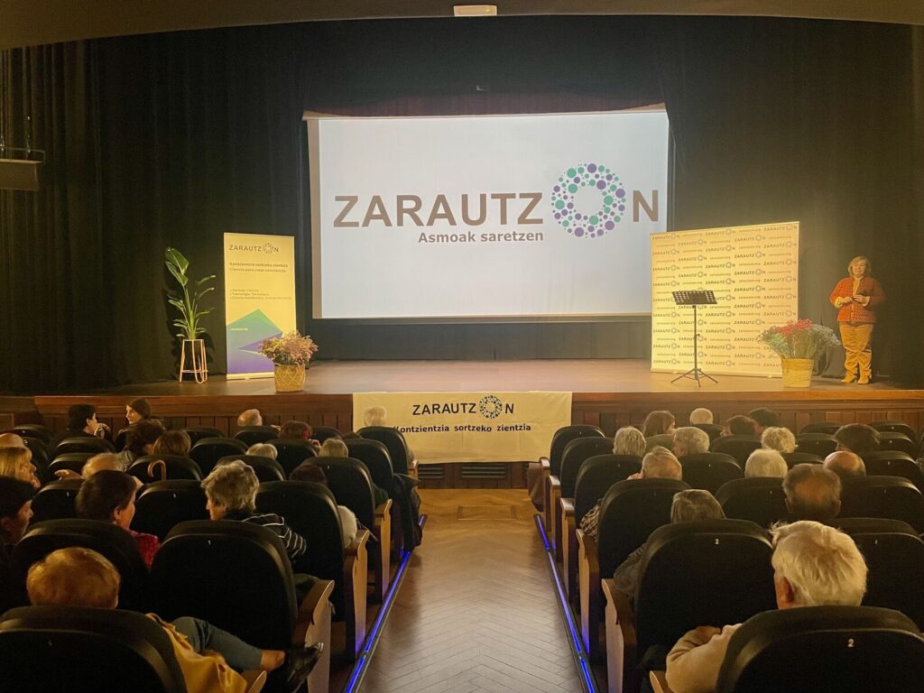 Escenario del Modelo Aretoa con el logotipo de ZarautzOn y la ponente